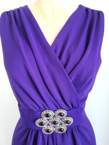 Dramatic vintage-1960s, polyester, draped neckline, sleeveless, floor-length gown with large brooch  - Fashionconservatory.com